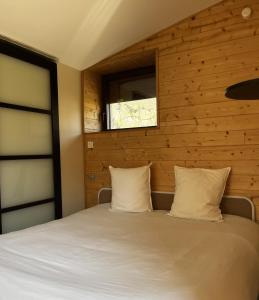 a bedroom with a bed with a window at La Petite Cabane in Saint-Affrique