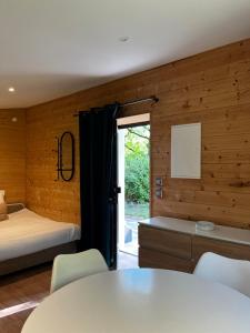 a bedroom with a bed and a table and chairs at La Petite Cabane in Saint-Affrique
