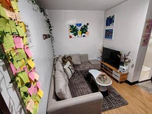 a living room with a couch and a tv at Casita Bonita in Marilao