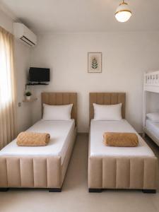 two beds sitting next to each other in a room at Guest House Emi in Berat