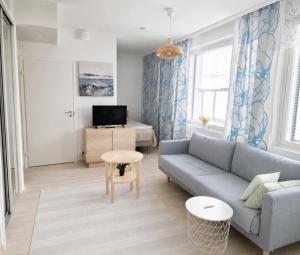 a living room with a couch and a table at Beautiful Modern City Apartment in Kuopio