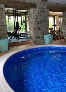 a large blue swimming pool in a house at Les Chambres du 4 in Saint-Benoît-du-Sault