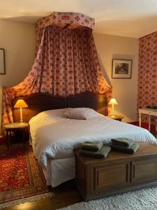 a bedroom with a large bed with a canopy at Les Chambres du 4 in Saint-Benoît-du-Sault +8 photos