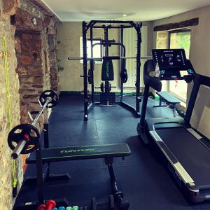 a gym with several tread machines in a room at Les Chambres du 4 in Saint-Benoît-du-Sault