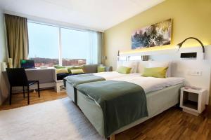 a hotel room with a large bed and a desk at Scandic Opalen in Gothenburg +69 photos