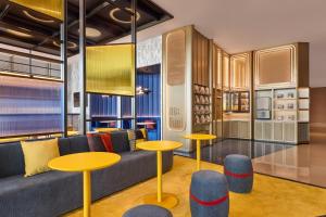 a living room with a couch and tables at Aloft by Marriott Xiamen Xiangan in Xiamen