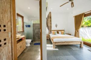 a bedroom with a bed and a bathroom at Bali Mynah Villas, Balangan Beach in Jimbaran