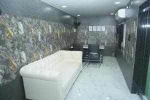 a living room with a white couch and a table at V Rooms in Pendurti