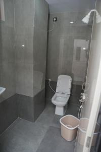 a small bathroom with a toilet and a shower at V Rooms in Pendurti