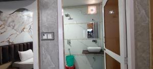 a bathroom with a mirror and a sink in a room at HOTEL BUDDHA in Kushinagar