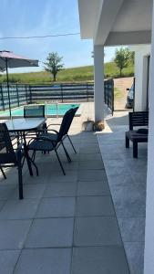 a patio with a table and chairs and a pool at Villa Emerald in Šiljkovača
