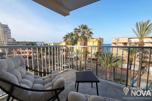a balcony with a view of the ocean and palm trees at Marina Tavernes in Tavernes de Valldigna