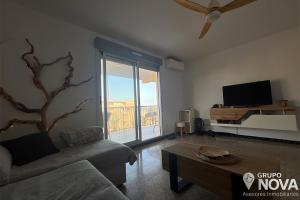 a living room with a couch and a tv at Marina Tavernes in Tavernes de Valldigna