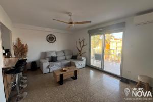 a living room with a couch and a table at Marina Tavernes in Tavernes de Valldigna +5 photos