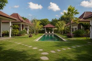 a yard with a swimming pool in a villa at Bali Mynah Villas, Balangan Beach in Jimbaran