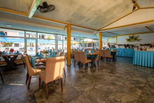 a dining room with tables and chairs and windows at Side Temple Hotel in Side