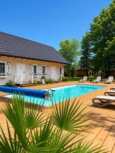 a house with a swimming pool with a surfboard next to it at Osada Zator Family Resort & SPA in Zator