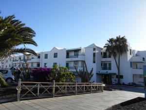 a row of apartment buildings in a parking lot at RealRent Costa Teguise Beach in Costa Teguise