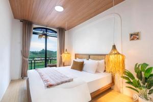 a bedroom with a white bed and a large window at Diamond Cabin 3 in Diyeng
