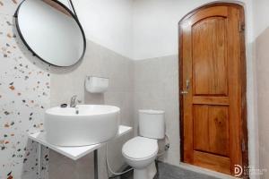 a bathroom with a toilet and a sink and a mirror at Diamond Cabin 3 in Diyeng +30 photos
