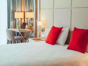 a bedroom with a bed with red pillows and a desk at ibis Styles Istanbul Bomonti in Istanbul