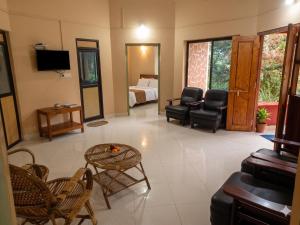 a living room with a bed and a table and chairs at Mahout Resort Wayanad - An Experiential Jungle Stay with Waterfall in Kalpetta +67 photos