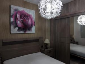 a bedroom with a bed and two chandeliers at apartamento peñon de jolucar in Torrenueva +5 photos