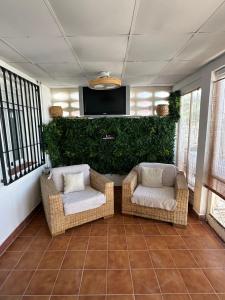 two wicker chairs and a television in a living room at apartamento peñon de jolucar in Torrenueva