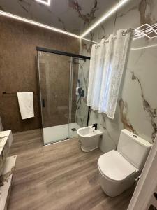 a bathroom with a shower and a toilet and a sink at apartamento peñon de jolucar in Torrenueva