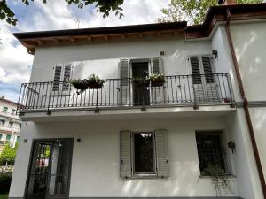 a white house with a balcony with flowers on it at Emilia94 in Anzola dell'Emilia