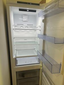 an empty refrigerator with its door open and empty shelves at Studio between two stations in Šiauliai +8 photos
