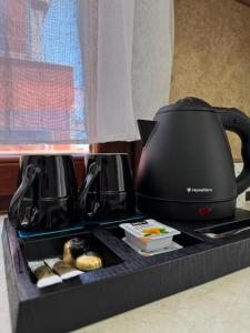 a black tea kettle sitting on a stove with donuts at Almeta Apartments Port in Chios