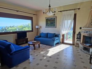 a living room with a blue couch and a tv at House with View in Agia Paraskevi