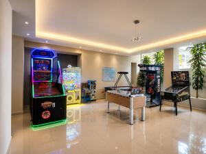 a room with two arcade games and a table at All Senses Ocean Blue Sea Side Resort & Spa By Anayia All Inclusive Resorts in Kremasti