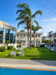 a resort with palm trees and a swimming pool at All Senses Ocean Blue Sea Side Resort & Spa By Anayia All Inclusive Resorts in Kremasti +27 photos