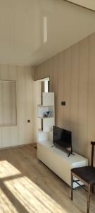 a living room with a laptop on a white shelf at Nino in Kaspi