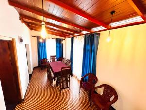 a dining room with a table and chairs at Mandaram Nuwara Sunset Villa in Nuwara Eliya