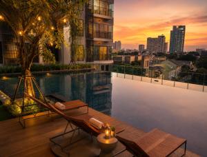 a pool on the roof of a building with a sunset at Ultra luxury Condo in Bangkok