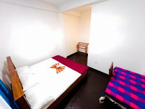 a bedroom with two beds and a chair at Mandaram Nuwara Sunset Villa in Nuwara Eliya