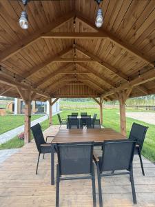 a wooden pavilion with a wooden table and chairs at Winnica Osada Moszczonne in Moszczonne