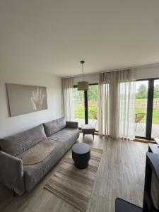 a living room with a couch and a table at Winnica Osada Moszczonne in Moszczonne
