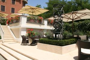 a patio with chairs and an umbrella and a statue at Hotel Villa Duse in Rome