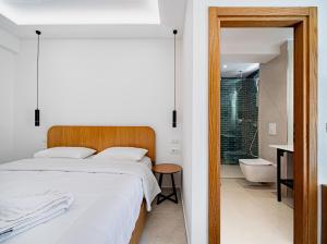 a bedroom with a bed and a bathroom with a tub at Vourtaréa Guesthouse in Himare +176 photos