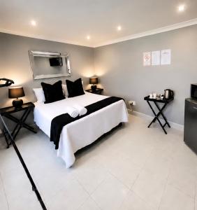 a bedroom with a large white bed and a television at Zhantique Guest House 2- Unit 1 in Boksburg