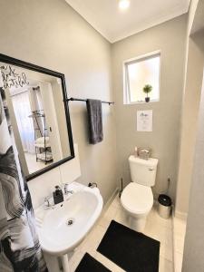 a bathroom with a white toilet and a sink at Zhantique Guest House 2- Unit 1 in Boksburg