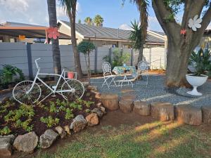 a bike parked in a yard next to a tree at Zhantique Guest House 2- Unit 1 in Boksburg +5 photos
