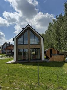a small house with glass windows in a yard at Winnica Osada Moszczonne in Moszczonne