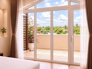 a bedroom with a large sliding glass door at Chau Pho Hotel in Chau Doc +47 photos
