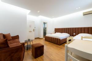 a hotel room with a bed and a couch at Hotel Vila Mare in Durrës