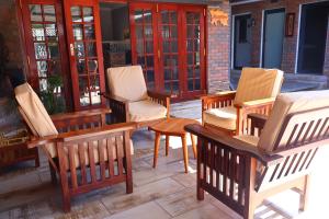 a group of chairs and tables on a patio at Villa de Chazha Guesthouse in Francistown